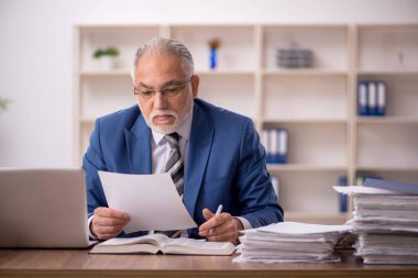 Ofiste çalışan yaşlı bir erkek.