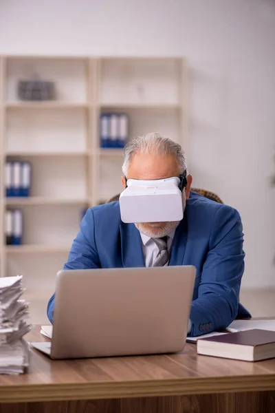 Verouderde mannelijke werknemer draagt virtuele bril in het kantoor — Stockfoto