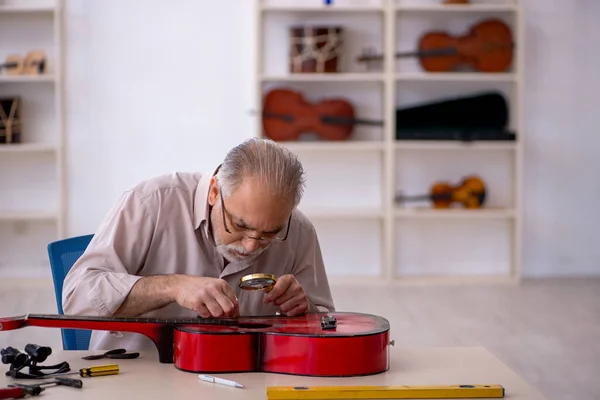 Régi férfi szerelő hangszereket javít a műhelyben — Stock Fotó