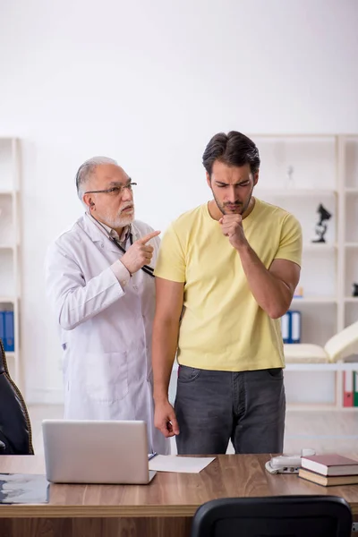 Young male patient visiting old male doctor — Stock Photo, Image