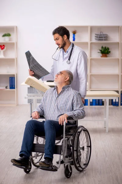 Oude gewonde man op bezoek bij jonge mannelijke arts radioloog — Stockfoto