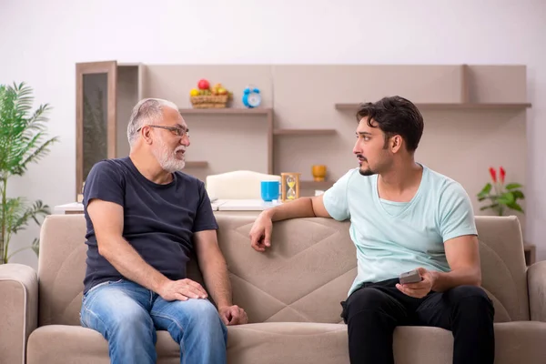 Pai e filho assistindo tv durante pandemia — Fotografia de Stock