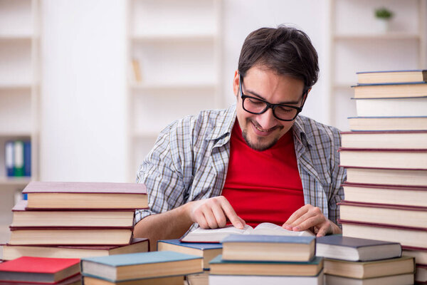 Young male student and too many books in the classroom