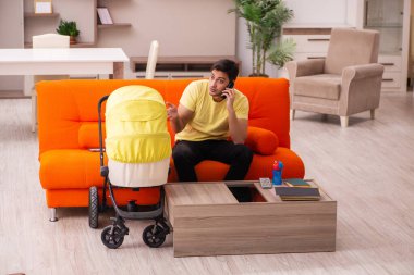 Genç adam evde yeni doğan çocuğa bakıyor.