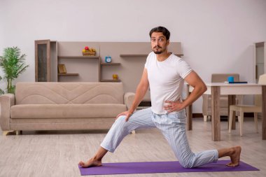 Genç adam evde spor yapıyor.