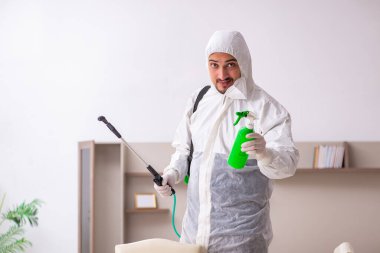 Genç erkek müteahhit evde haşere kontrolü yapıyor.