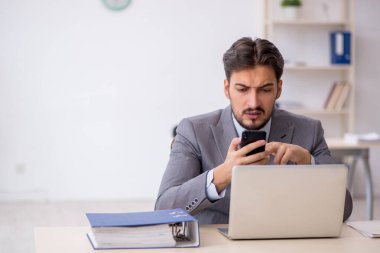 Ofiste çalışan genç bir erkek.