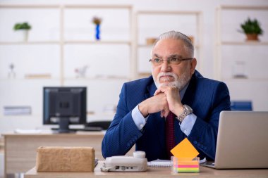 Ofiste çalışan yaşlı bir erkek.