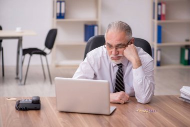 İş yerinde acı çeken yaşlı erkek çalışanlar