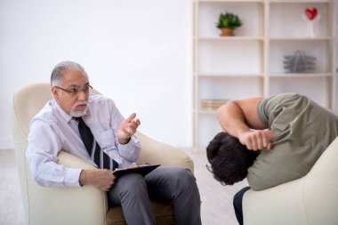 Genç adam yaşlı psikoloğu ziyaret ediyor.