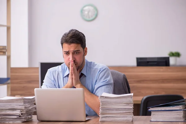 Jovem funcionário masculino infeliz com excesso de trabalho no escritório — Fotografia de Stock