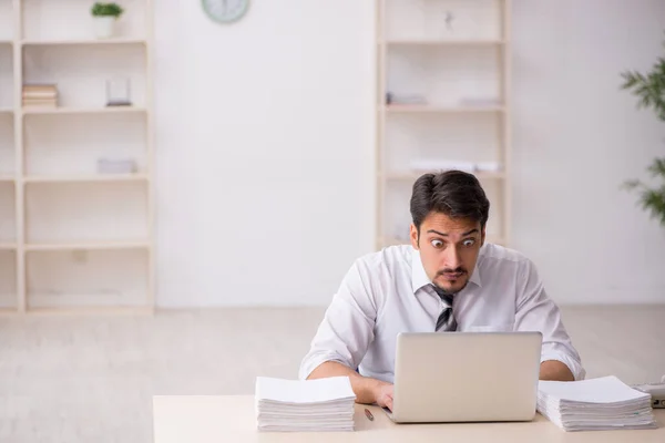 Joven empleado masculino descontento con el trabajo excesivo en la oficina —  Fotos de Stock