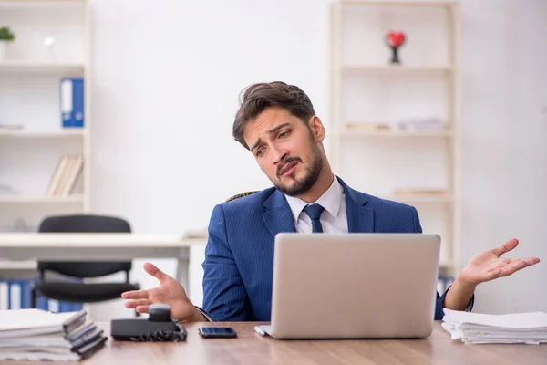 Ung manlig anställd missnöjd med överdrivet arbete på kontoret — Stockfoto