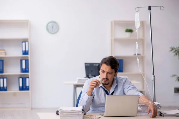 Giovane dipendente maschile che soffre sul posto di lavoro — Foto Stock