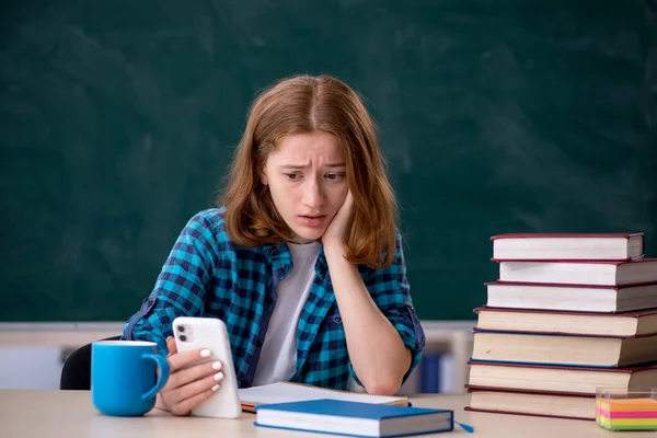 Jonge vrouwelijke student bereidt zich voor op examens in de klas — Stockfoto