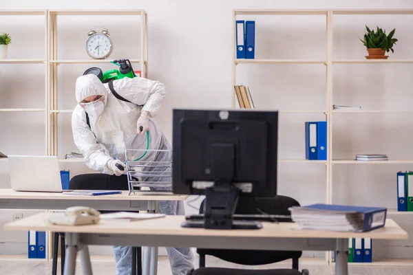 Velho empreiteiro masculino no conceito de desinfecção de escritório — Fotografia de Stock