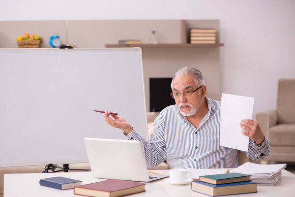 Old male employee working from home during pandemic