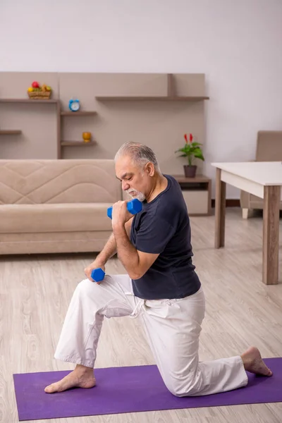 Oude man die thuis sport oefeningen doet — Stockfoto
