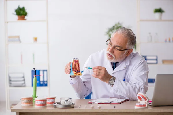 Vecchio medico dentista maschile che lavora in clinica — Foto Stock