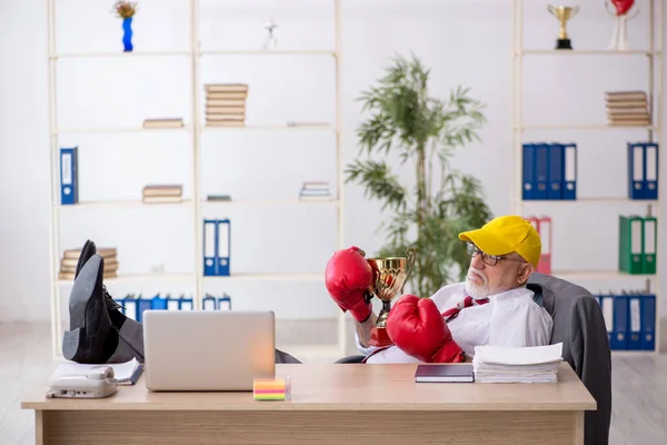 Old male employee boxer being awarded with golden cup — Stock Photo, Image