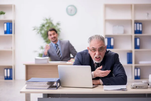 Двоє співробітників чоловічої статі працюють в офісі — стокове фото