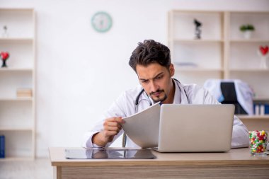 Klinikte çalışan genç erkek doktor.