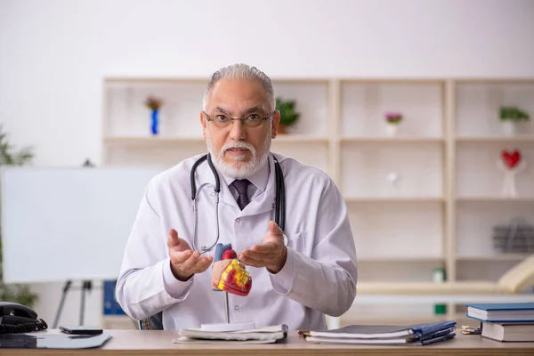 Ο ηλικιωμένος καρδιολόγος γιατρός που εργάζεται στην κλινική — Φωτογραφία Αρχείου