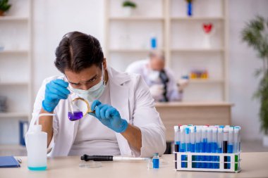 Laboratuvarda çalışan iki erkek kimyager.