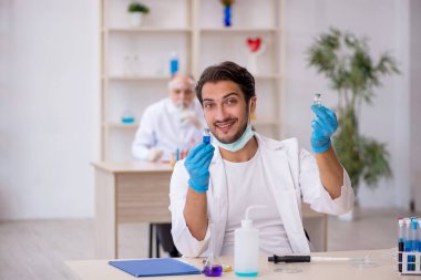 Laboratuvarda çalışan iki erkek kimyager.