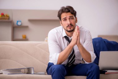 Genç erkek çalışan salgın sırasında evden çalışıyor.