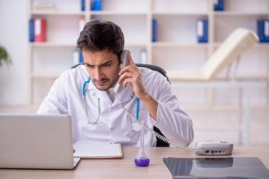 Klinikte çalışan genç erkek doktor.