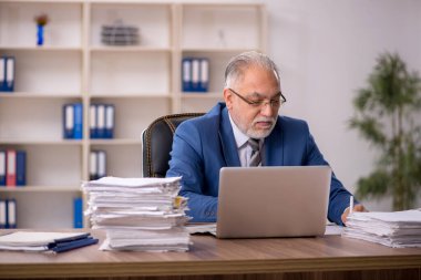 Ofiste çalışan yaşlı bir erkek.