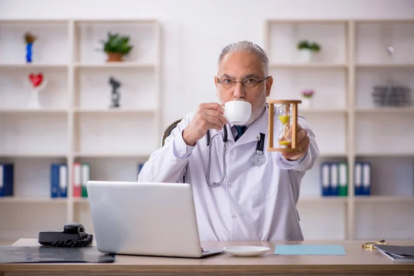 Old male doctor in time management concept — Stock Photo, Image