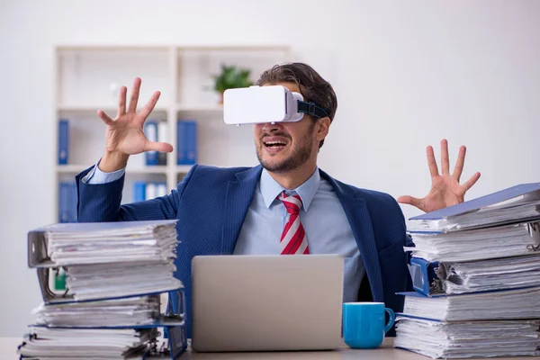 Mladý muž zaměstnanec těší virtuální brýle na pracovišti — Stock fotografie