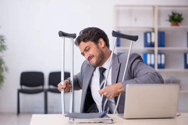 Young male employee after car accident working in the office — Stock Photo, Image
