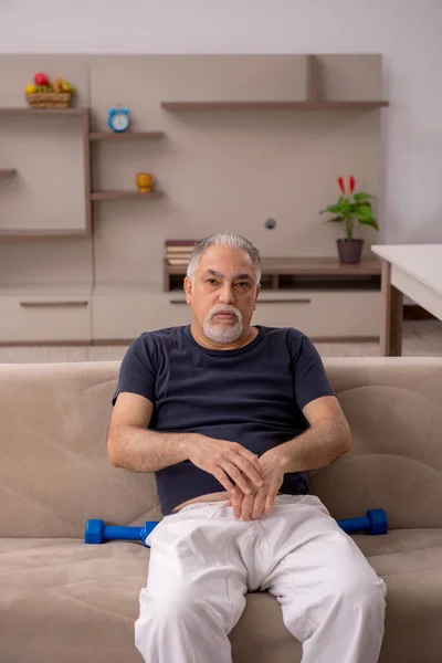 Viejo haciendo ejercicios deportivos en casa — Foto de Stock