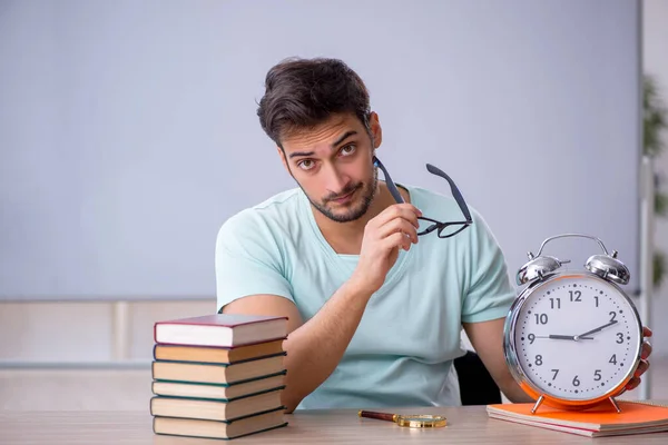 Young male student in time management concept in the classroom — Stock Photo, Image
