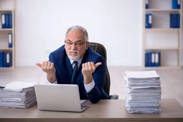 Velho empregado masculino e muito trabalho no escritório — Fotografia de Stock