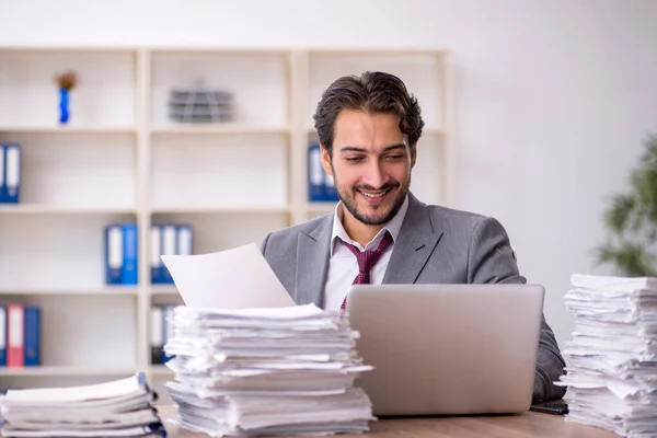 Ung manlig anställd och för mycket arbete på kontoret — Stockfoto