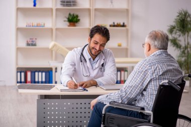 Tekerlekli sandalyedeki yaşlı adam genç erkek doktoru ziyaret ediyor.