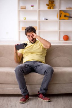 Evde sanal gözlük takan genç bir adam.