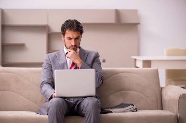 Genç erkek çalışan salgın sırasında evden çalışıyor.