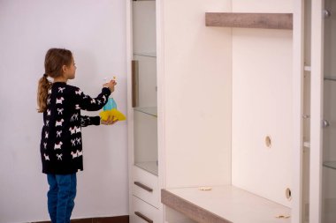 Küçük kız evde ev işi yapıyor.