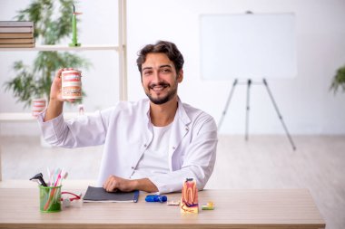 Klinikte çalışan genç erkek dişçi.