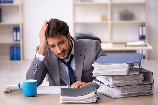 Junge männliche Mitarbeiter und zu viel Arbeit im Büro — Stockfoto