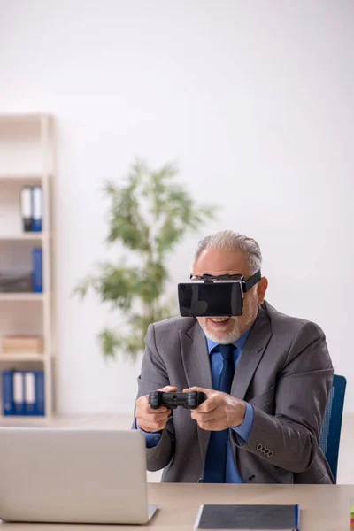 Gammal manlig anställd njuter av virtuella glasögon på arbetsplatsen — Stockfoto