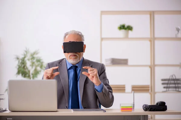 Starý muž zaměstnanec těší virtuální brýle na pracovišti — Stock fotografie