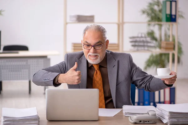 Old male employee drinking coffee during break — Stock Photo, Image