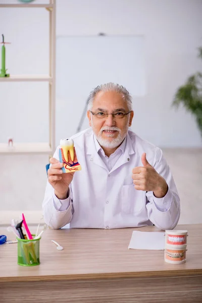 Gammal manlig tandläkare som arbetar på kliniken — Stockfoto