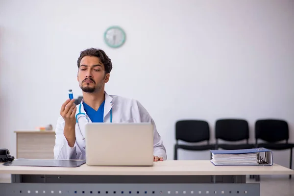 Ung manlig läkare som arbetar på kliniken — Stockfoto